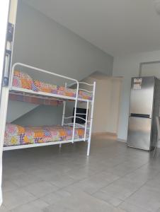 a room with two bunk beds and a refrigerator at Casa al mare Sicilia in Fondachello