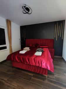 a bedroom with a red bed with towels on it at Diamond Stan na Dan in Kiseljak