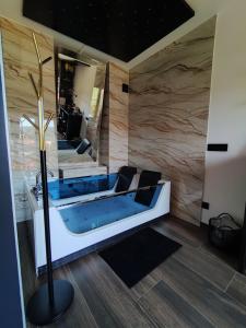 a bathroom with a tub with a large mirror at Diamond Stan na Dan in Kiseljak