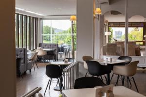 Un restaurante con mesas y sillas y una ventana. en Hotel Santiago Apóstol, en Santiago de Compostela