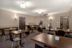 uma sala vazia com mesas e cadeiras e uma cozinha em Days Inn by Wyndham Stouffville em Stouffville