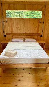 een bed in een houten kamer met een raam bij Emy's Villa in Batoemi