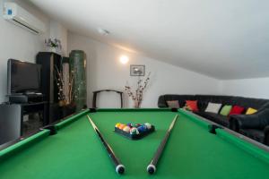 a living room with a pool table with cuesticks at Villa Nada with 6 bedrooms in Vodnjan