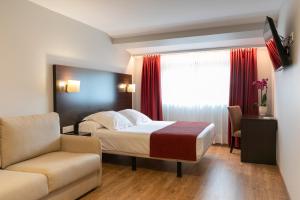 una habitación de hotel con una cama y una silla en Hotel Santiago Apóstol, en Santiago de Compostela 37 fotos más