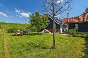 a house with a table and chairs in a yard at Het Spoel in Kuilenburg