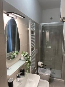 a bathroom with a sink and a toilet and a mirror at Montanelli 26 in Pisa