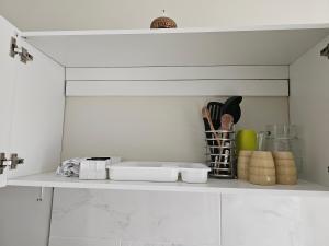 a kitchen shelf with utensils on top of it at Apartamento Compacto muy cerca del Irtra in Ajaxá +6 photos