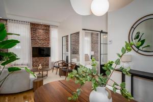 Una sala de estar con una mesa y algunas plantas. en Le 1911 Luxury Condo, en Quebec