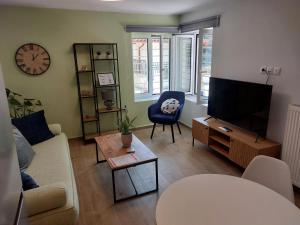a living room with a couch and a tv and a chair at Diamond Apartment in Lamía