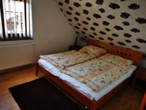 a bedroom with a bed with a comforter on it at Pekný dom s parkovaním in Pribylina