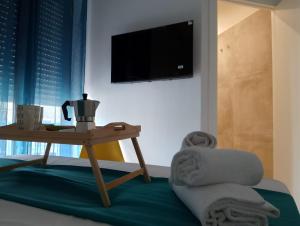 un salon avec une table et une télévision dans l'établissement Sweet Rooms San Francesco, à Naples