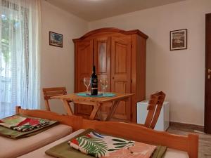 a dining room with a table and a bottle of wine at Apartments and rooms Bova in Baška