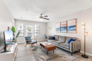 a living room with a couch and a tv at Spacious 2BR King Suites w Pool, Gym, Laundry - Close to Downtown in Austin