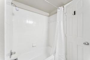 a white bathroom with a shower and a tub at Spacious 2BR King Suites w Pool, Gym, Laundry - Close to Downtown in Austin