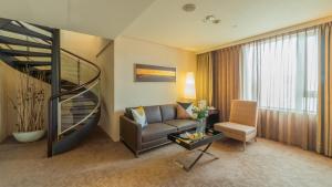 a living room with a couch and a spiral staircase at Tempus Hotel in Taichung