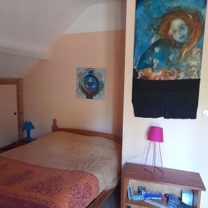 a bedroom with a bed and a painting on the wall at Guernazelles in Le Controis En Sologne