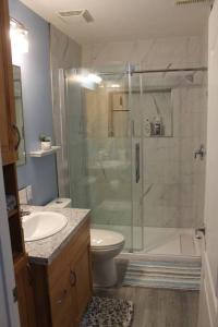 a bathroom with a shower and a toilet and a sink at Cozy Lodge Suite in Sylvan Lake +20 photos