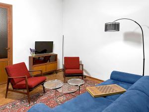 a living room with a blue couch and two chairs at Your Cascade Home: In Yerevan Heart in Yerevan
