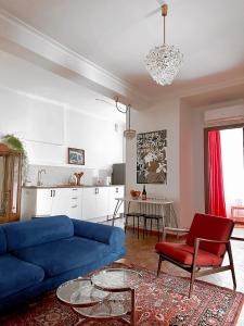 a living room with a blue couch and a red chair at Your Cascade Home: In Yerevan Heart in Yerevan