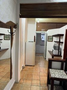een keuken met een koelkast en een tafel en stoelen bij Les Mangroves in Mahébourg
