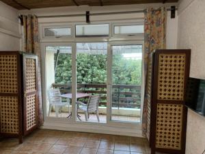 een kamer met een groot raam en een tafel en stoelen bij Les Mangroves in Mahébourg