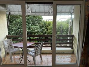 een terras met een tafel en stoelen op een balkon bij Les Mangroves in Mahébourg +1 foto