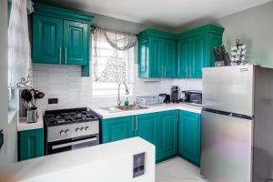 a green kitchen with white appliances and green cabinets at LeLuxe Cedar Valley Suite A in Woods