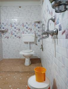 a bathroom with a toilet and a bucket in it at Holiday home stay Ranchi in Rānchī