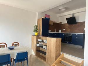 a kitchen with a table and blue chairs at Summer time in Pisak +22 photos