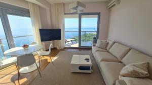 a living room with a couch and a table at Altezza Luxury Apartment 11 in Budva