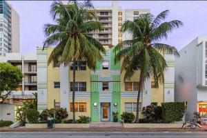 un bâtiment avec deux palmiers devant lui dans l'établissement Tranquil 2 bed 1 bath at Beach, Glimpse of the Ocean, à Miami Beach