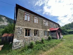 an old stone house in a grassy field at Tsknari Oda in Oni
