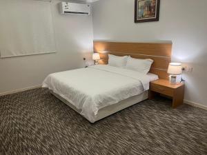 a hotel room with a bed and two lamps on a table at فخامة المدينة in Medina