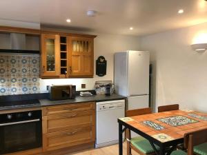 a kitchen with a table and a white refrigerator at The Barn in Tollerton