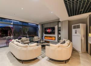 a living room with two couches and a fireplace at Intercity Hotel Istanbul Airport in Arnavutköy