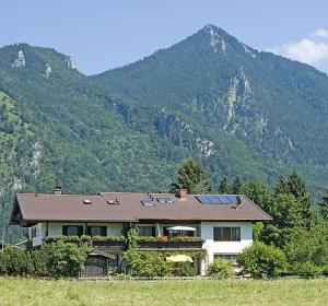 una casa con paneles solares en la cima de una montaña en Gästehaus Weißenbacher-Ferienwohnungen, en Marquartstein