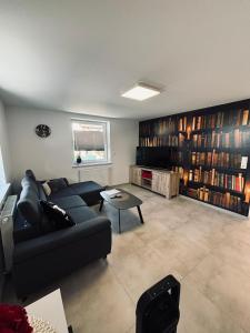 a living room with a couch and a table and bookcases at Rhein Appartements in Rheinhausen