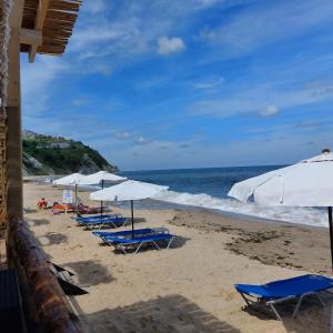 a group of chairs and umbrellas on a beach at Sun Holidays Byala in Byala