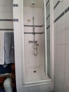 a shower with a glass door in a bathroom at Chambres d'hôtes calmes sur jardin Paris Batignolles in Paris
