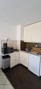 a kitchen with white counters and white cabinets at Appartement Bidart Plage in Bidart +8 photos