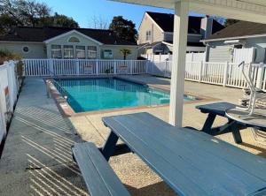 a swimming pool with a picnic table and a bench at Seaside Haven in Myrtle Beach