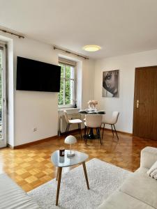 a living room with a flat screen tv and a table at Ferienwohnung mit Balkon und Seeblick in Bregenz +11 photos