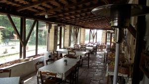 pusta restauracja ze stołami, krzesłami i oknami w obiekcie Fattoria Il Noce B&B w mieście Manduria