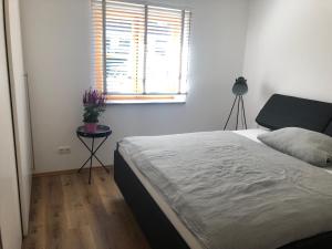 een slaapkamer met een bed, een raam en een tafel bij FreiRaum in Ofterschwang