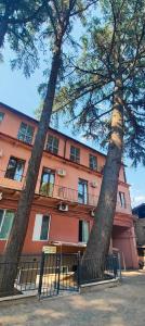 two large trees in front of a building at Light Hotel in Tbilisi City