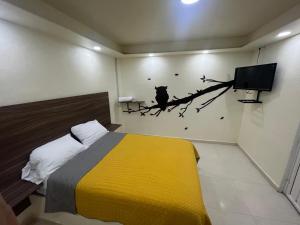 XometlaPosada Love的卧室里有一张床，树枝上还有一只鸟