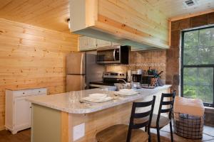cocina con paredes de madera y barra con sillas en Mountain Views at Dolly's Castle Unit 3, en Sevierville
