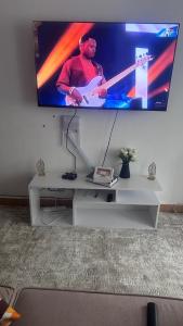 Un televisor en una pared con una guitarra encima. en JB apartment, en Kisumu