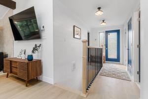 a living room with a tv on a wall at The Cozy Woodpecker Cottage in Notre-Dame-de-l'Île-Perrot