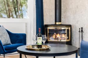 a table with two wine glasses and a fireplace at The Cozy Woodpecker Cottage in Notre-Dame-de-l'Île-Perrot